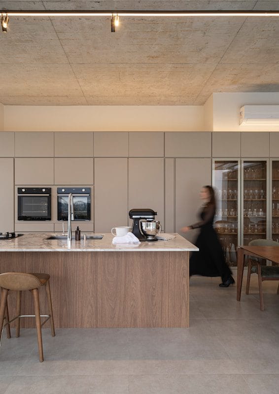 Modern kitchen with island and woman walking