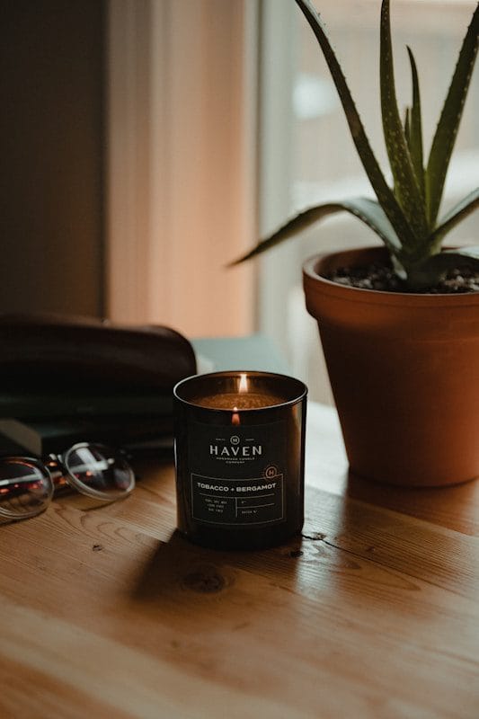 brown ceramic cup beside black framed eyeglasses on brown wooden table