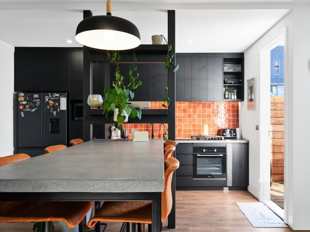 Modern kitchen with black cabinets and dining table.