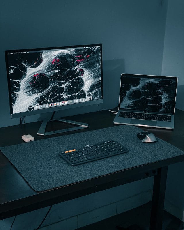 silver flat screen computer monitor and black computer keyboard on black wooden desk